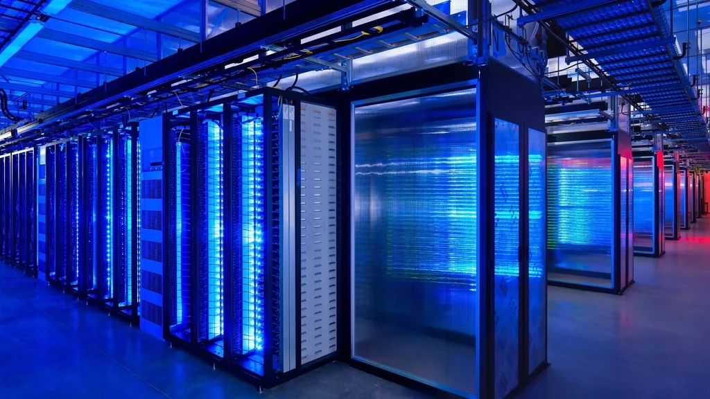 Een gang tussen serverkasten in een datacentrum, verlicht door blauwe en groene statuslampjes.